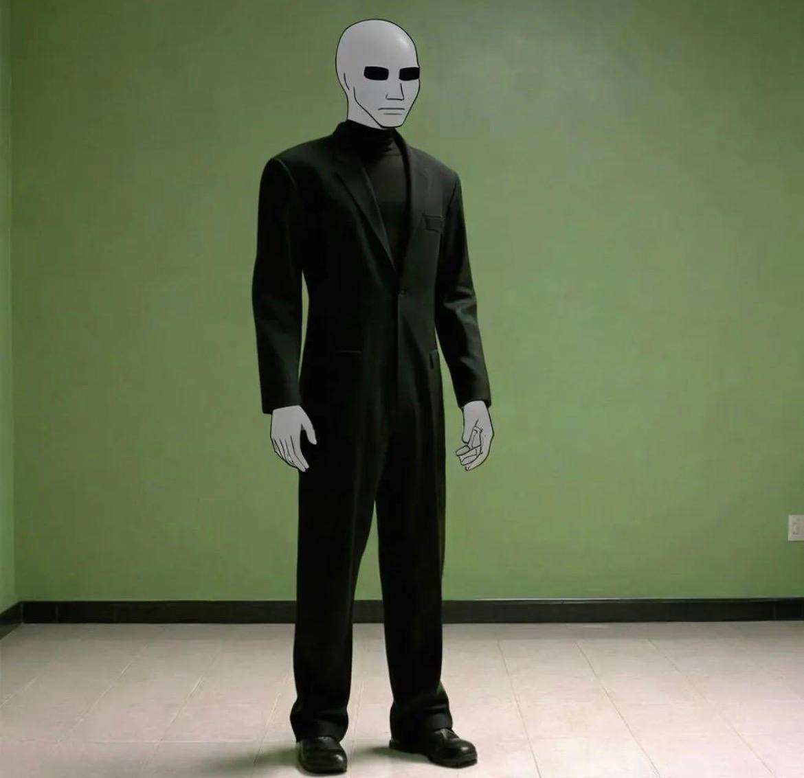 A blank-faced, bald figure in a black suit stands silently in an empty olive-green room.